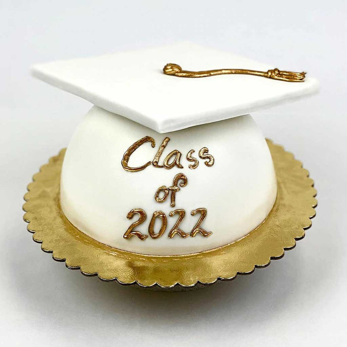 White Grad Cap Cake featuring a golden tassel, gold base, and a βClass of 2022β message in gold