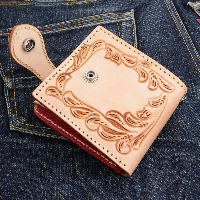 Snap strap and back closure detail on the veg-tan biker wallet, showing the reinforced leather tab