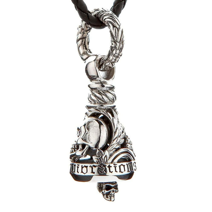 Detailed view of gothic 'vibrations' engraved band, skull clapper, and ornate leaf motifs on sterling silver biker guardian bell
