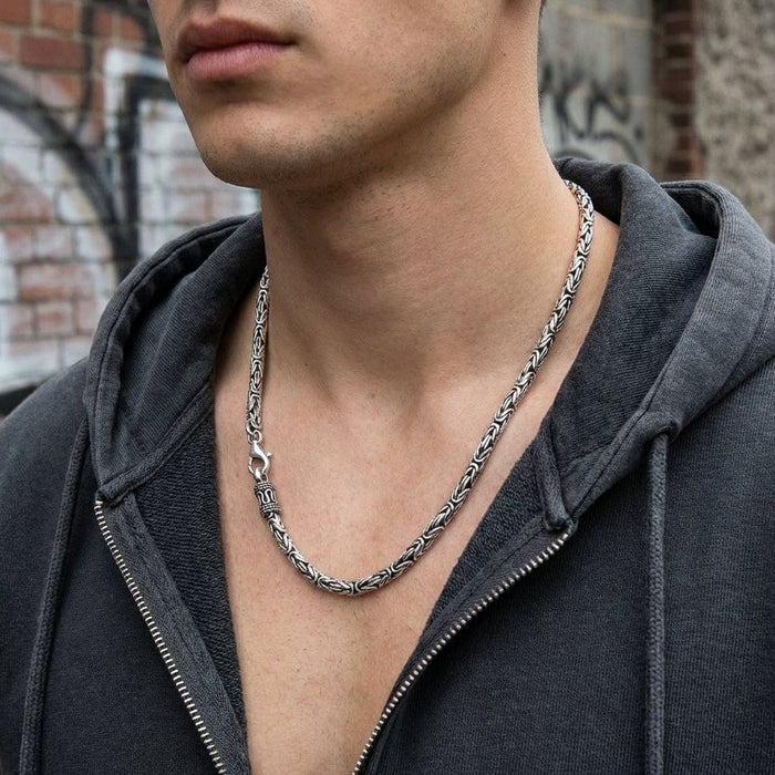 Man wearing 3mm sterling silver Byzantine chain necklace with gray hoodie showing how chain sits on neck
