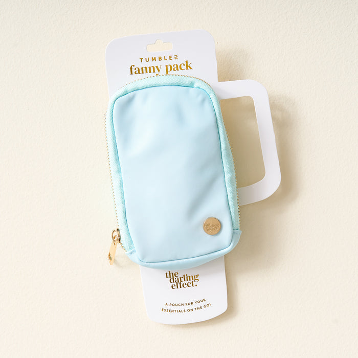 The Darling Effect Aqua Tumbler Fanny Pack features a stylish light blue, water-resistant pouch with a gold zipper—perfect for carrying essentials on the go. Packaging is labeled "Tumbler fanny pack" and "The Darling Effect.
