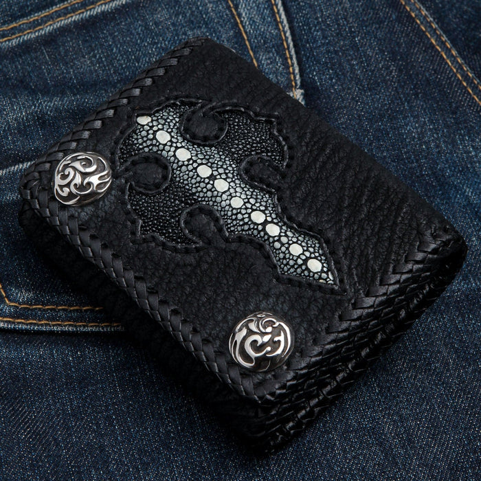 Front of the stingray cross wallet shown upright on blue jeans, two ornate sterling silver snaps at opposite corners