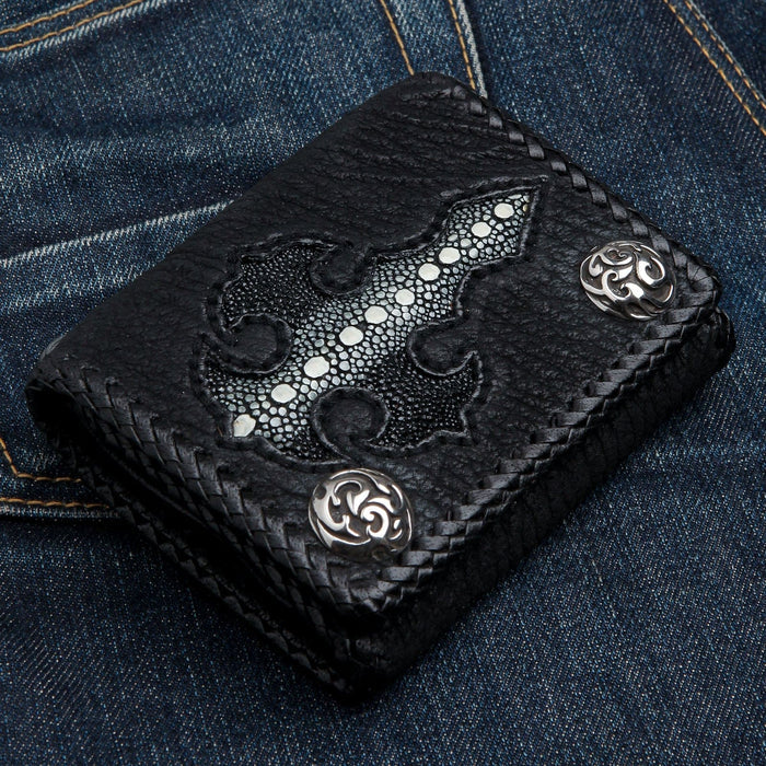 Overhead view of the black biker wallet on denim, white-beaded stingray cross inlay set into pebbled cowhide