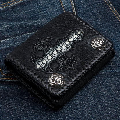 Overhead view of the black biker wallet on denim, white-beaded stingray cross inlay set into pebbled cowhide