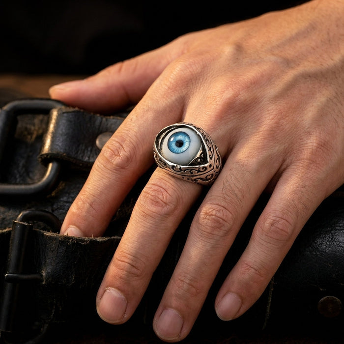 Man's hand wearing the large blue evil eye ring resting on a leather belt, showing real on-finger scale