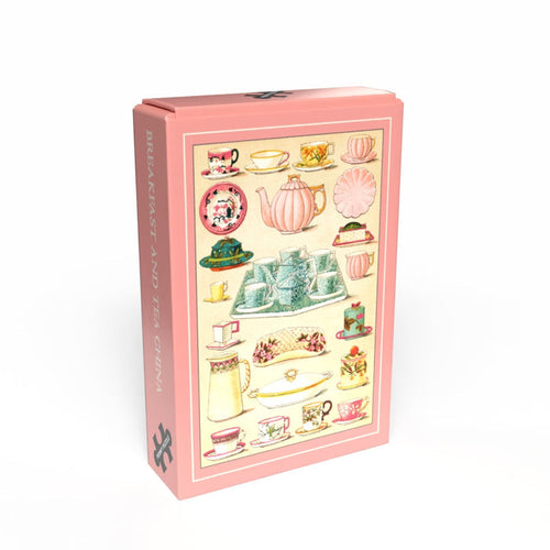 A pink rectangular box from Penny Puzzle, featuring vintage breakfast and tea china illustrations and "BREAKFAST TEA CHINA" on the side. Contains a charming 99 piece jigsaw puzzle for vintage lovers.
