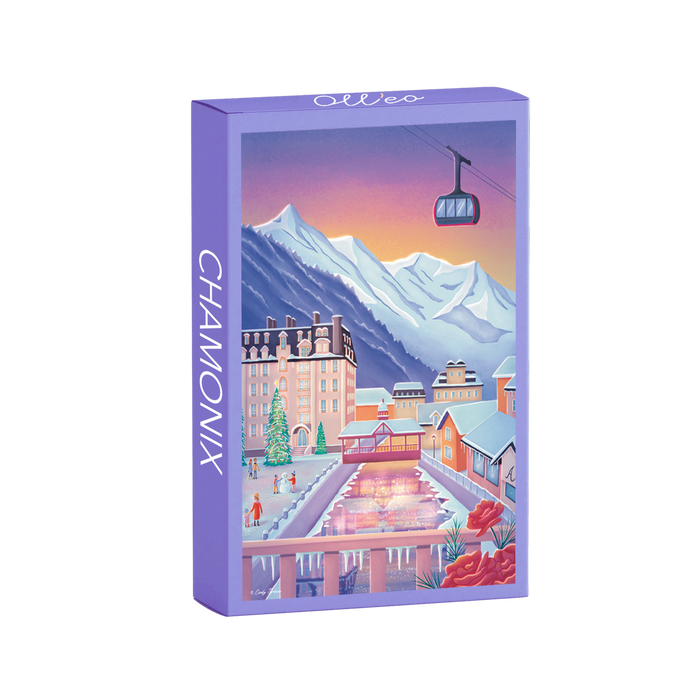 The Chamonix | 99 Piece Jigsaw Puzzle by Olleo Puzzles features Cindy Tardiou's winter scene with mountains, buildings, gondola, and skating rink at sunset—beautiful to display once completed.