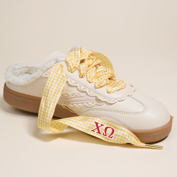 The Darling Effect’s Chi Omega Step It Up Shoelaces feature yellow gingham with red ΧΩ Greek letters, designed to upgrade any white slip-on sneaker—ideal as a sorority gift.