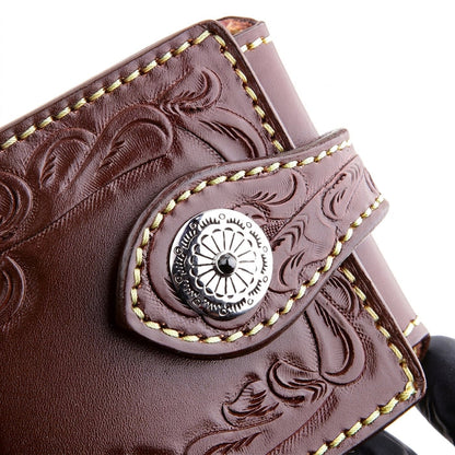 Macro of a 925 sterling silver concho set with a black onyx stone on a dark brown tooled leather wallet strap.
