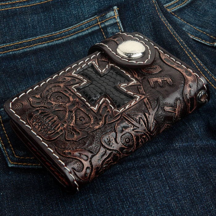 Angled view on denim showing the silver snap closure, white stitching, and textured black lizard cross inlay.