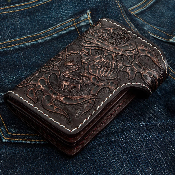 Bottom edge profile of the folded dark brown cowhide wallet on denim, revealing thick leather layers and tooled back details.
