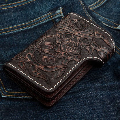 Bottom edge profile of the folded dark brown cowhide wallet on denim, revealing thick leather layers and tooled back details.