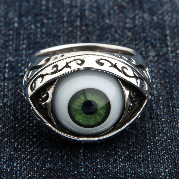 Dark green eyeball ring front view with detailed iris cabochon and oxidized filigree almond bezel on denim background