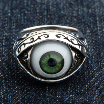 Dark green eyeball ring front view with detailed iris cabochon and oxidized filigree almond bezel on denim background