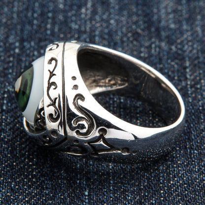 Interior angle showing the band's open recess and filigree shoulder of the dark green eyeball ring
