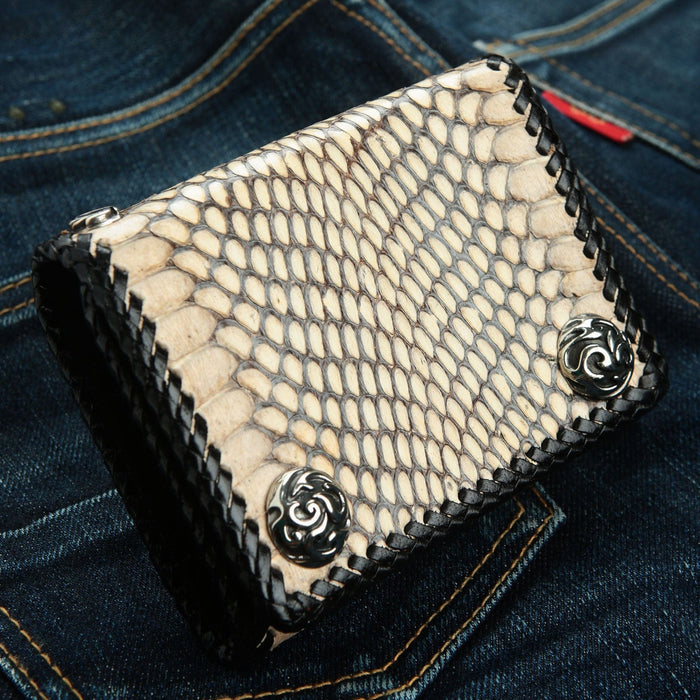 Close-up detail of the 925 sterling silver snap button with flame motif on the snake wallet.