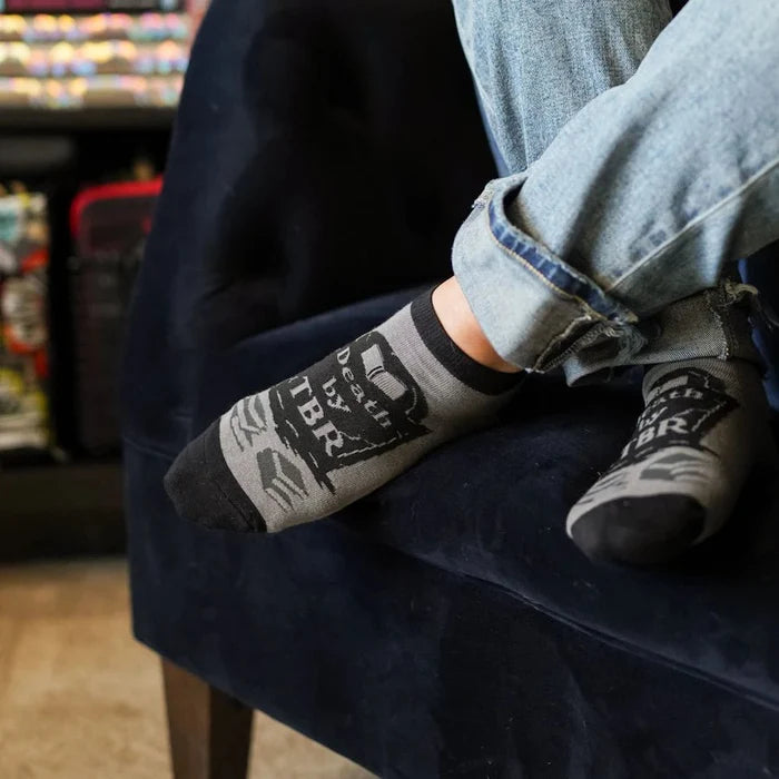 Ankle Socks feature a tombstone that reads "Death by TBR" with stacks of unread books; gray ankle socks with black design