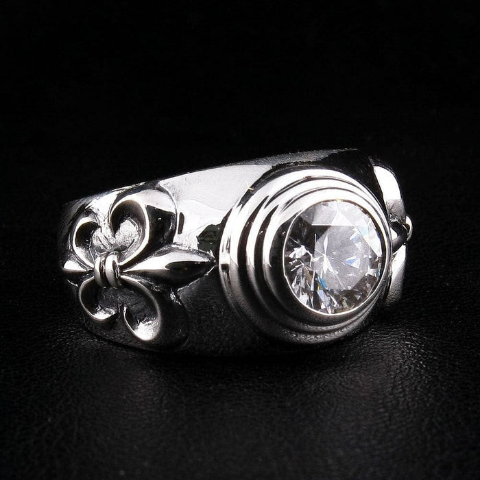 Side angle view of .925 sterling silver ring featuring Fleur De Lis motif and round-cut clear topaz gemstone