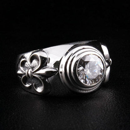 Side angle view of .925 sterling silver ring featuring Fleur De Lis motif and round-cut clear topaz gemstone