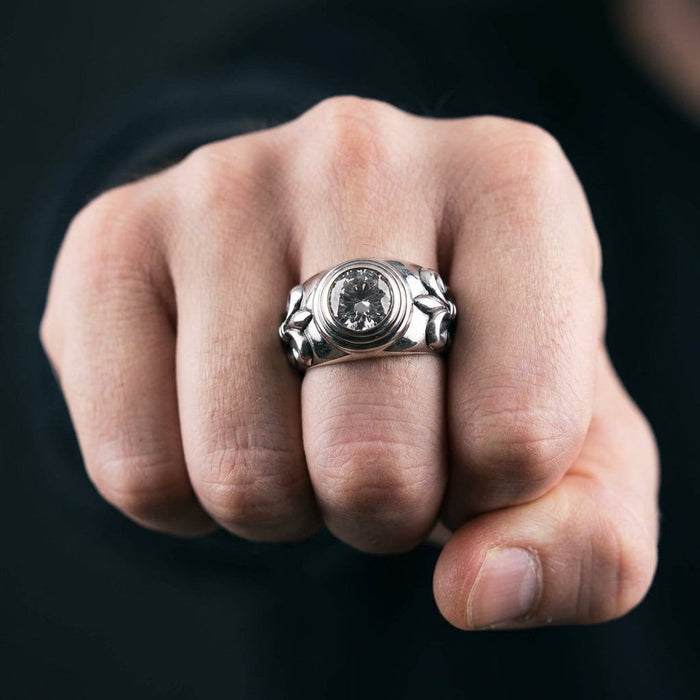 Man wearing sterling silver Fleur De Lis ring with 3-carat clear topaz on ring finger, fist pose showing ring detail