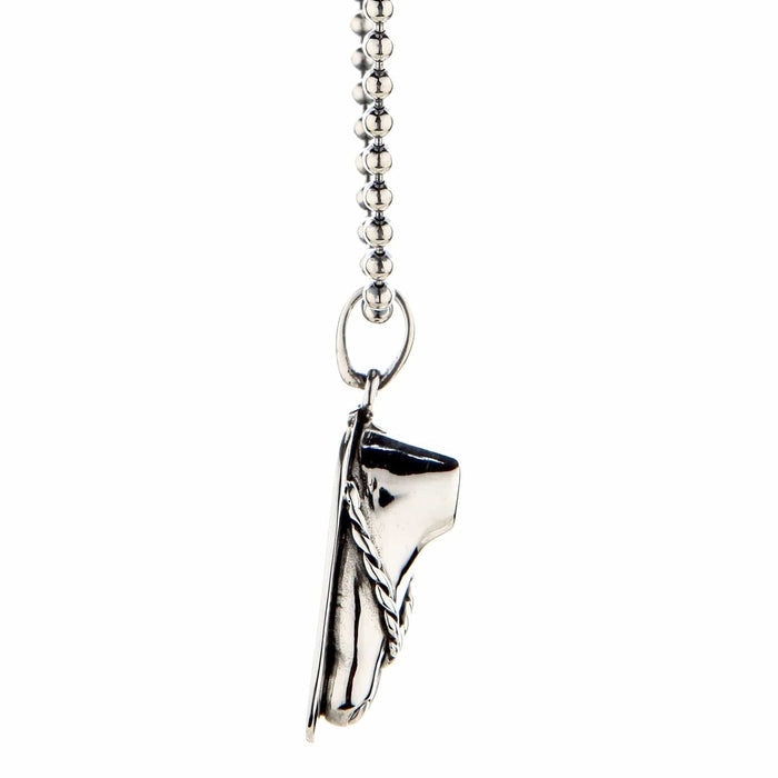 Sterling silver foot sandal pendant hanging from a silver ball chain, shown from a side angle on a white background