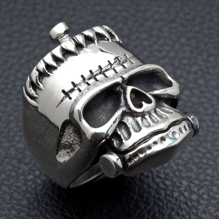 Right side angle of handcrafted Frankenstein skull silver ring showing jaw bolt and oxidized finish