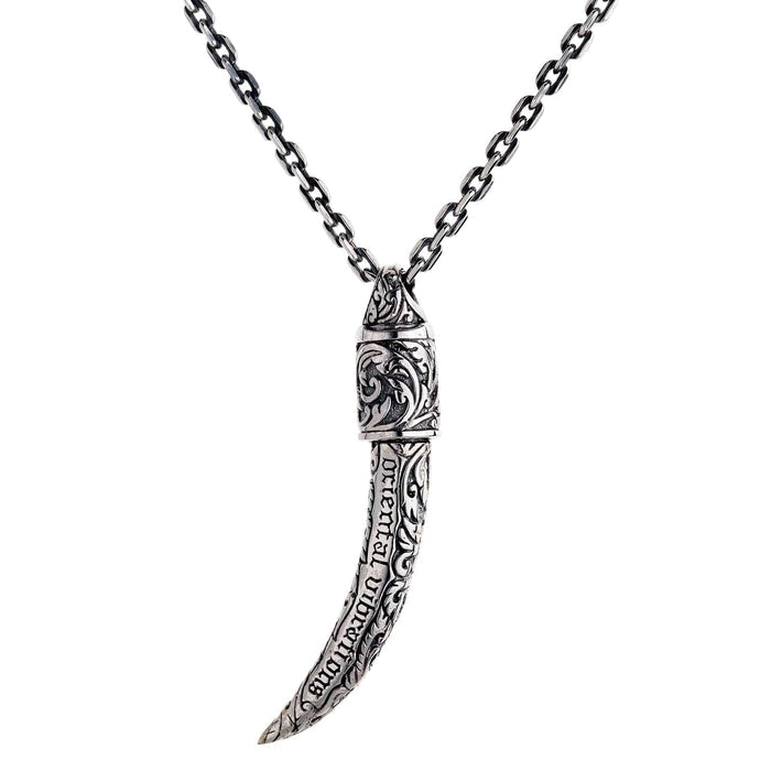 A premium sterling silver tusk pendant with "oriental vibrations" and intricate scrollwork engravings along its body.