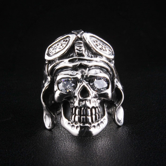 A direct front view of a solid sterling silver German skull ring, clearly showing its sparkling diamond eyes and detailed pilot helmet.