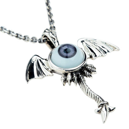 An angled view of the sterling silver monster pendant on a chain, showing the bat wings and dark purple eye.