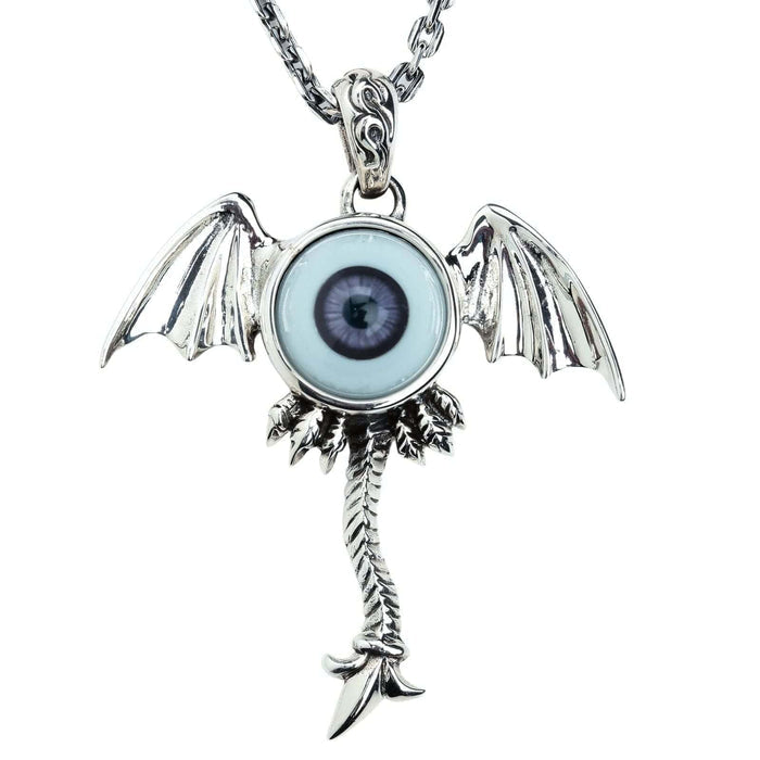 The surreal winged eyeball pendant in solid silver with a dark purple eye on a white background.