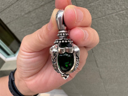 Front angle capturing the bright green flash of the moonstone secured in a heavy, pointed sterling silver setting.