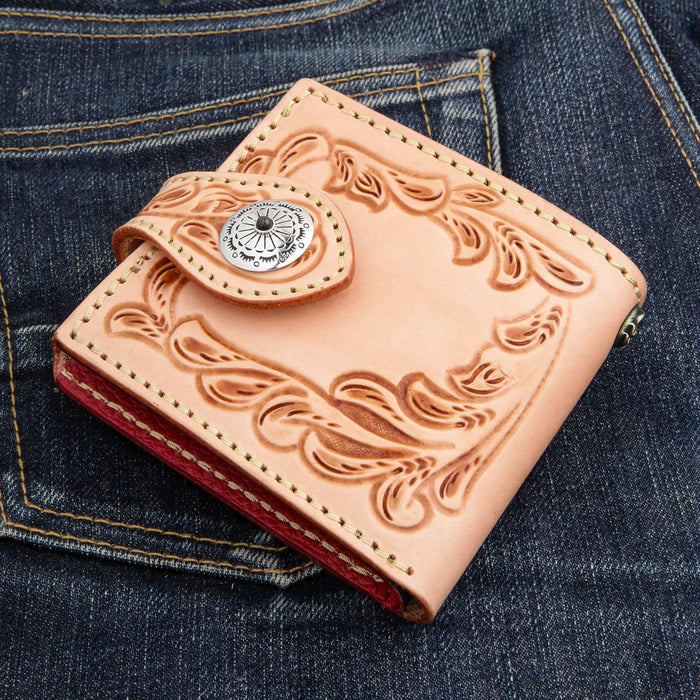 Angled front view of the tooled natural leather wallet showing Western floral carving and silver onyx concho