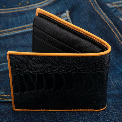 A partially open view of the men's exotic leather wallet, showing the black ostrich leg skin exterior and tan trim.