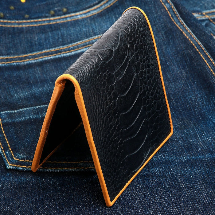 The exotic leather wallet standing on denim to show its profile.