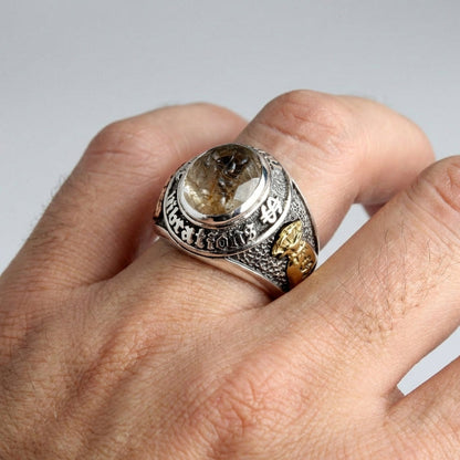A man's fist wearing the large, handcrafted lucky 777 wealth ring.