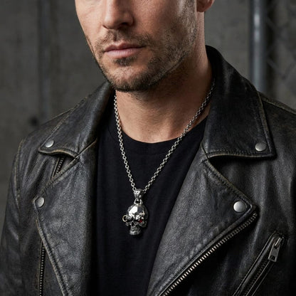 Male model in a black leather jacket wearing a silver punk skull biker pendant necklace.