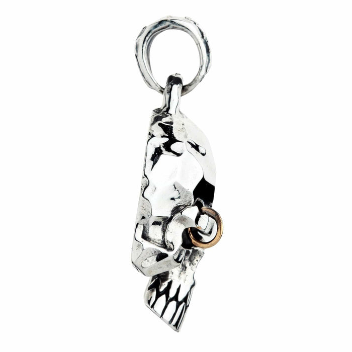 Side profile of the sterling silver punk skull pendant showing the bail loop, jawline and teeth, and the brow piercing ring.