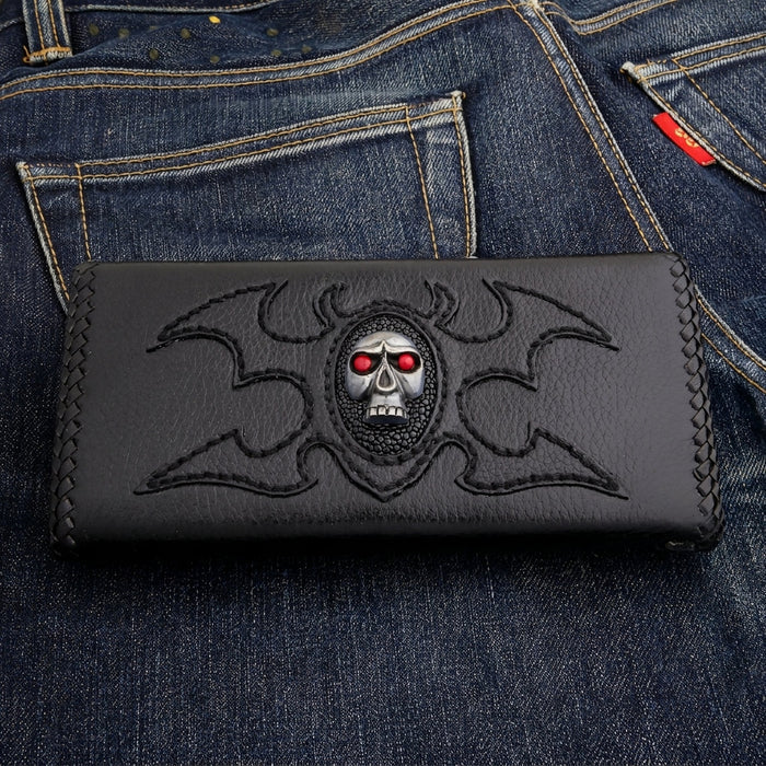 Red eye skull leather trucker wallet — silver-tone skull on a stingray oval with stitched tribal wings, black cowhide