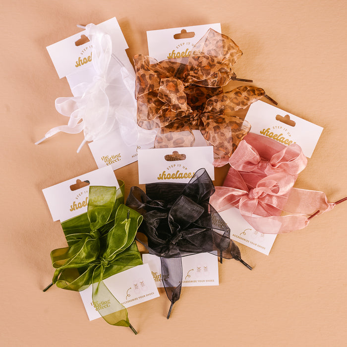 The Darling Effect’s Sheer Green Step It Up Shoelaces are displayed on a branded card on a beige background—an easy way to add style and color to your favorite shoes.