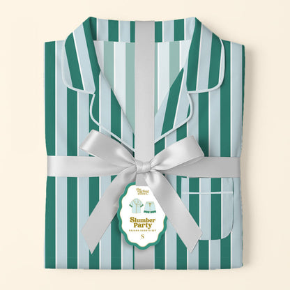 The Darling Effect’s Sicily Stripes Teal Slumber Party Pajama Shorts Set, in ultra-soft fabric with teal and light blue stripes, is folded and tied with a silver ribbon, featuring a gift tag showing a small pajamas illustration and "S" for size.