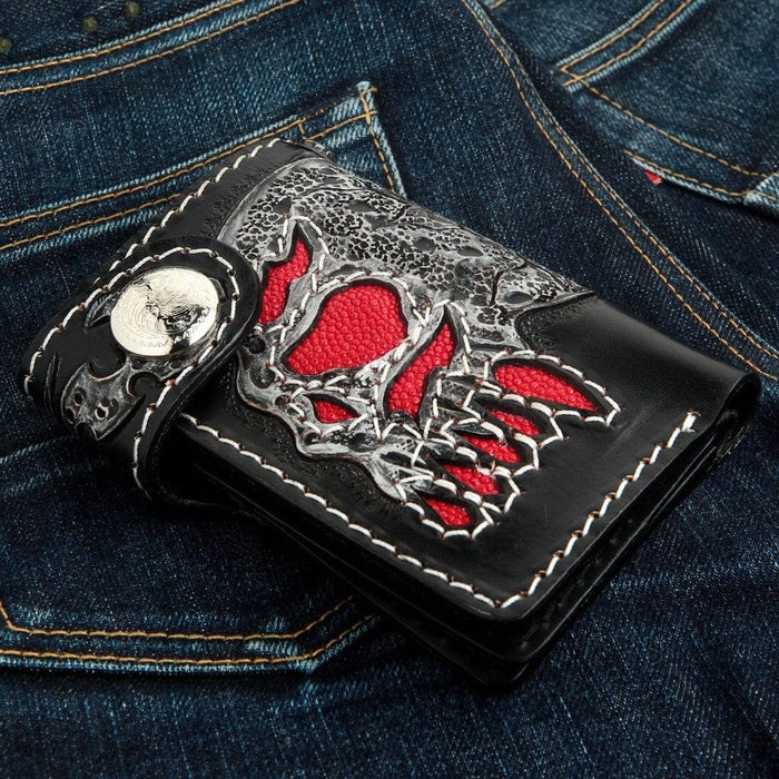Angled side view of black leather wallet highlighting 3D texture of the skull and silver snap closure