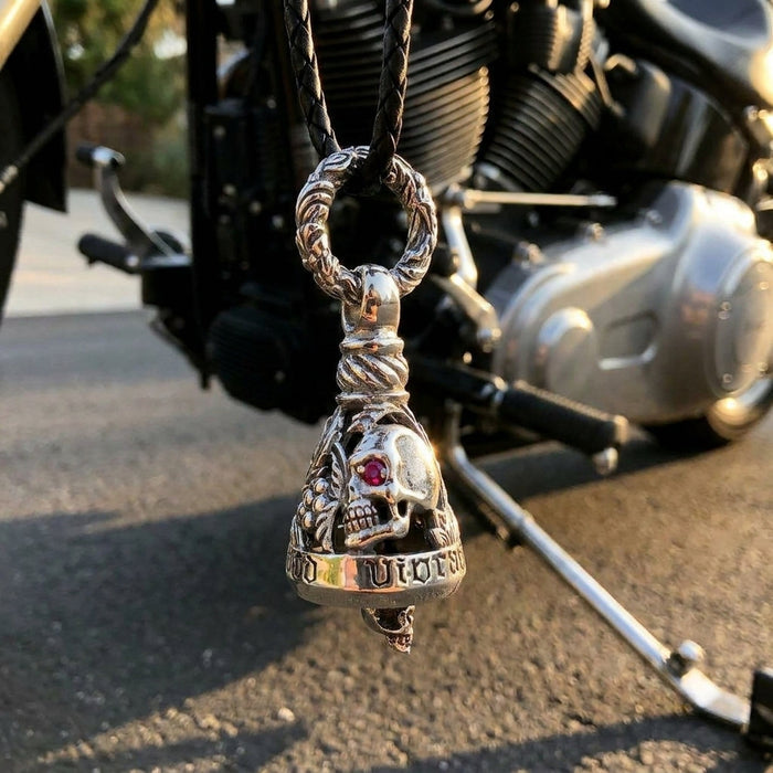 Ruby-eyed sterling silver skull Guardian Bell on a braided leather cord, mounted low on a cruiser's frame