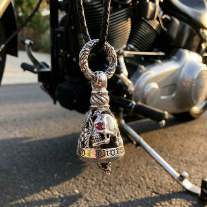 Ruby-eyed sterling silver skull Guardian Bell on a braided leather cord, mounted low on a cruiser's frame