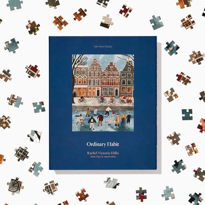 Snow Day in Amsterdam is a 500-piece puzzle by Ordinary Habit, featuring charming winter artwork of people ice skating before Amsterdam-style buildings—perfect for evoking cozy snow day vibes.