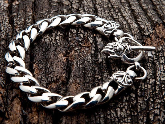 A close-up of the 'key to my heart' toggle clasp on the men's heavy silver curb bracelet.