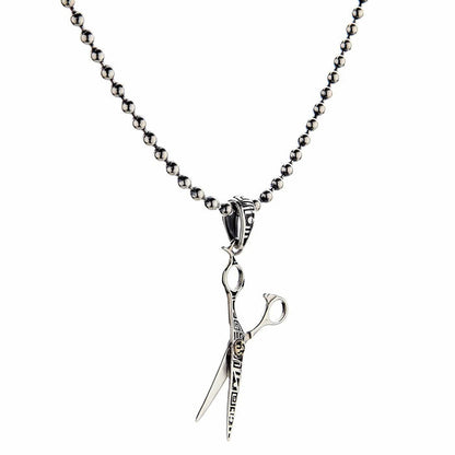 An angled view of the unique sterling silver scissors pendant, showing its polished finish.