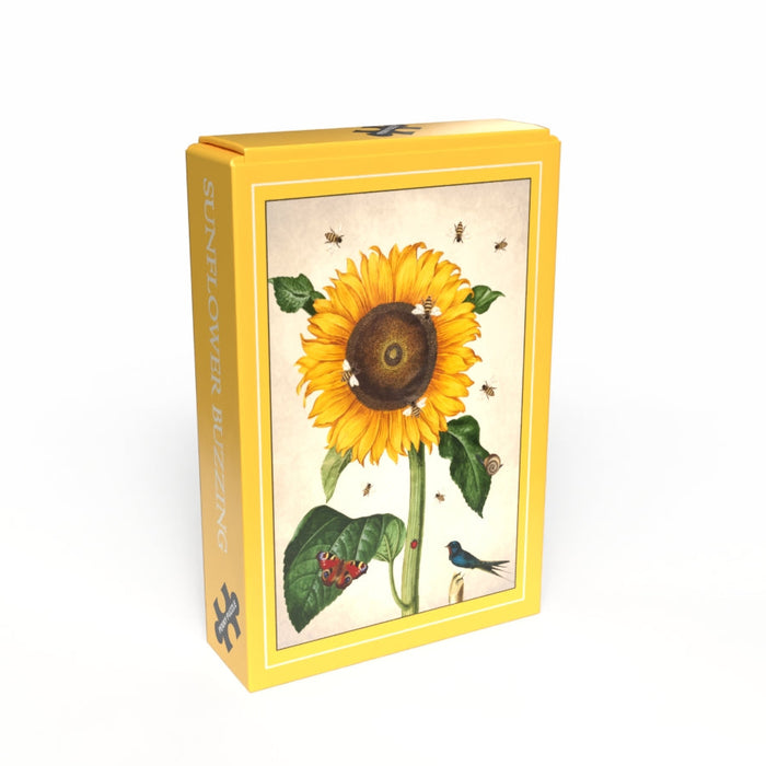 A yellow box featuring a sunflower, bees, ladybugs, and a bluebird; side label reads SUNFLOWER BUZZING. Penny Puzzle's Sunflower Buzzing 99 Piece Jigsaw offers a delightful vintage minipuzzle experience.