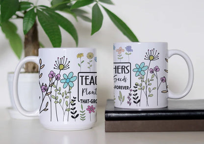 Teaching in Full Bloom white ceramic coffee mug featuring colorful whimsical flowers and a teacher-inspired message about planting seeds that grow, available in 11 oz and 15 oz sizes.