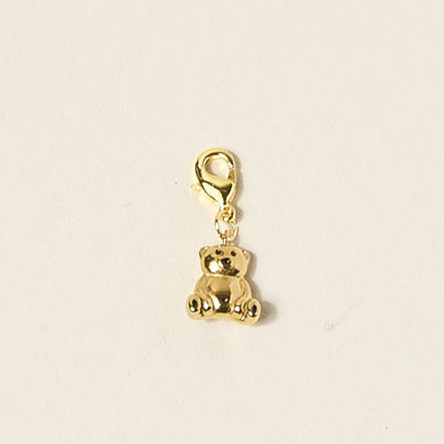 The Darling Effect's Teddy Bear Jewelry Charm Gold is a small, shiny gold charm with a lobster clasp, perfect for your favorite charm bar. Shown on a plain off-white background.
