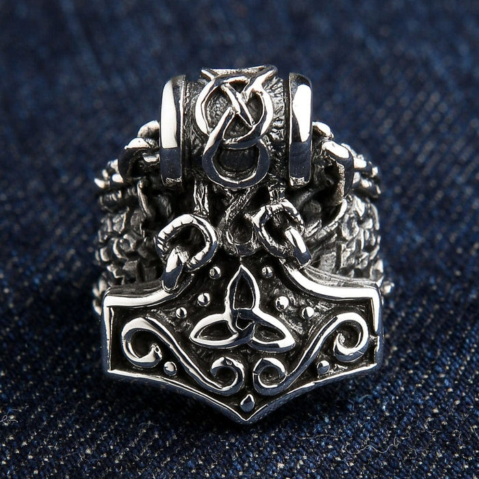 Close-up front view of Mjolnir ring showing intricate Norse knotwork and triquetra symbol